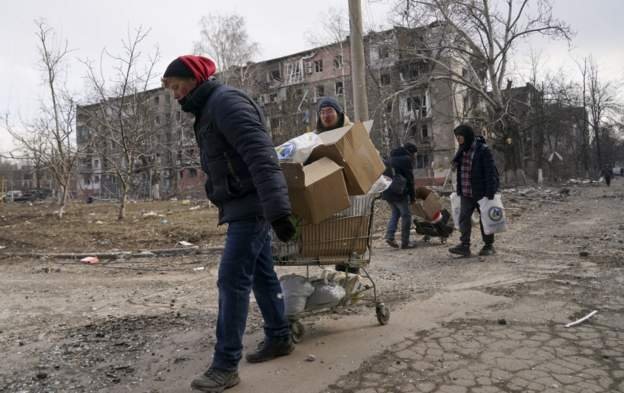 Mariupol residents carry some belongings