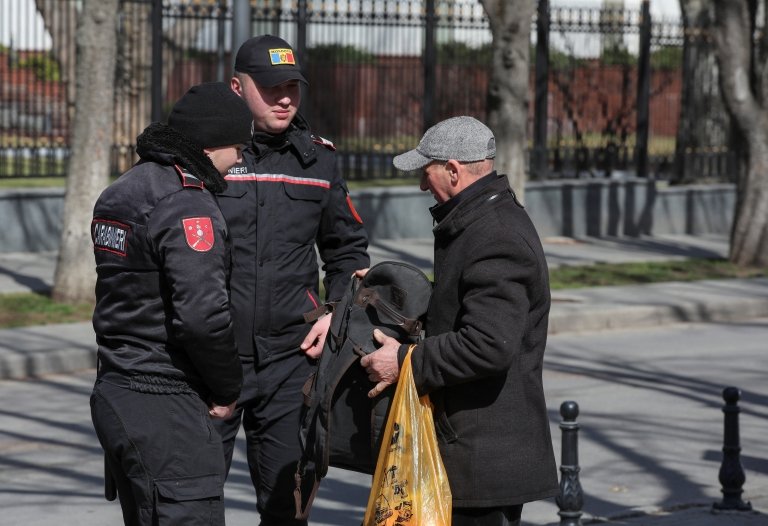ضباط إنفاذ القانون في مولدوفا يفحصون متعلقات رجل خلال احتجاج مناهض للحكومة في كيشيناو، مولدوفا، 12 مارس/آذار 2023