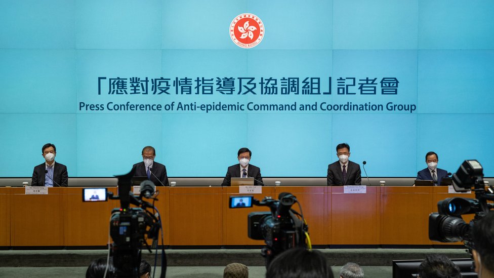 李家超（中）與抗疫官員在金鐘香港特區政府總部內出席新聞發佈會（8/8/2022）