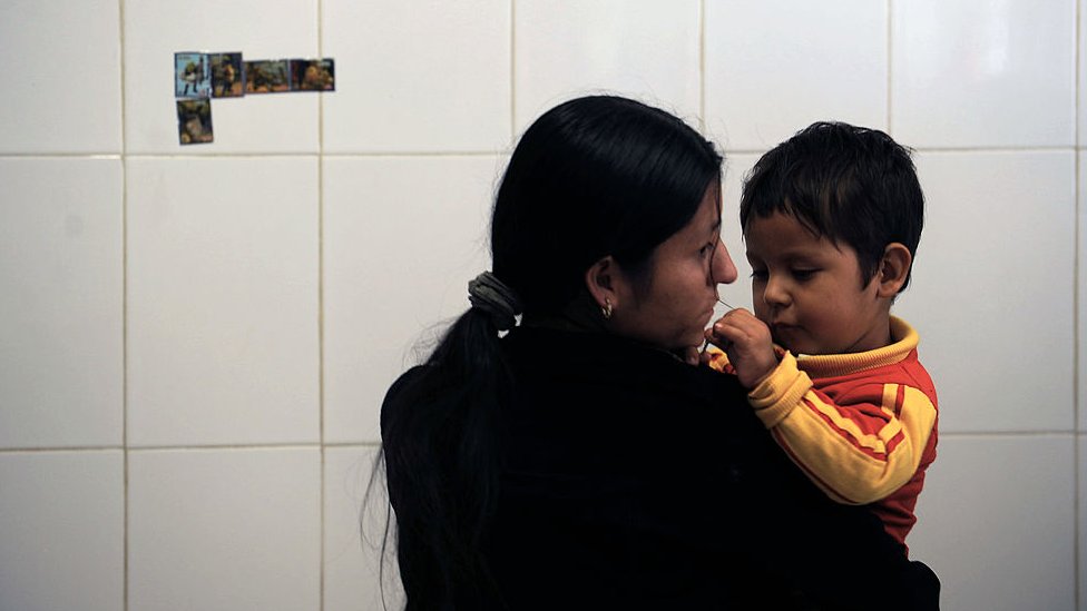 Una mujer con su hijo en la estación migratoria Siglo 21