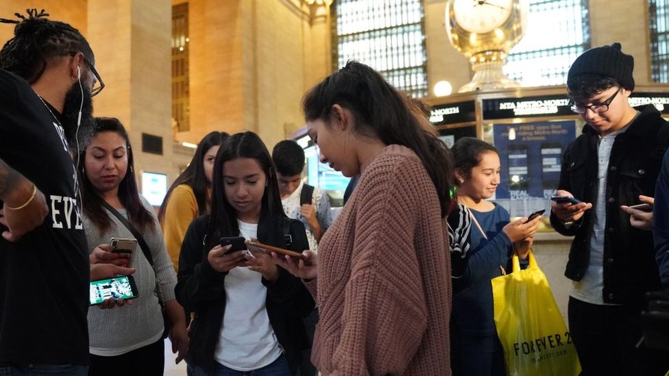 Люди смотрят в свои телефоны во время тревоги на Центральном вокзале Нью-Йорка