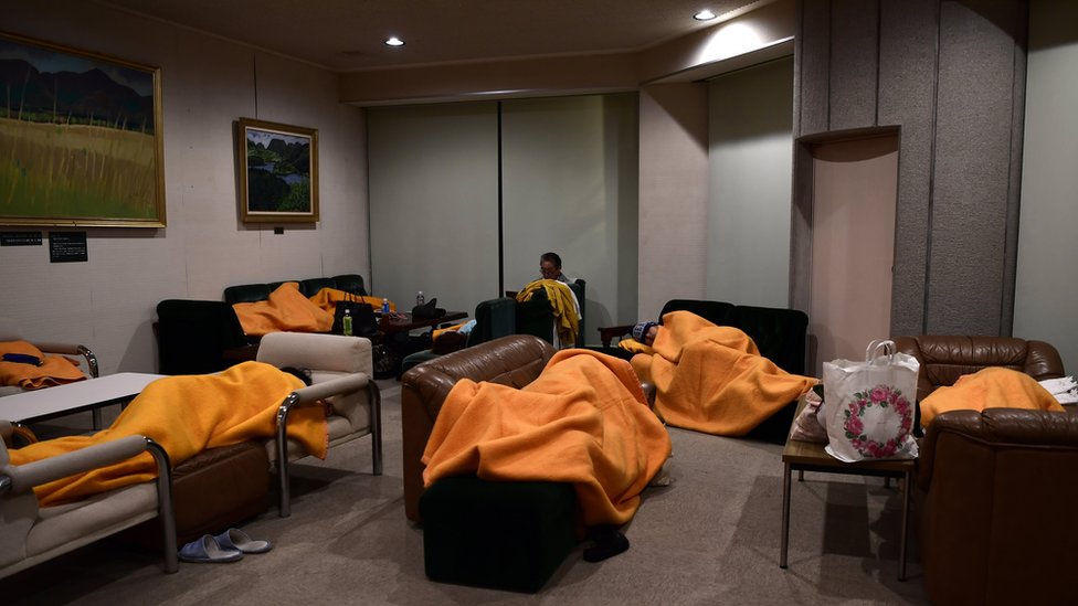 Evacuees sleep on makeshift beds in a shelter after emergency crews evacuated nearby hotel guests, in Sengokuhara, in Nakone province, Japan, 12 October 2019.