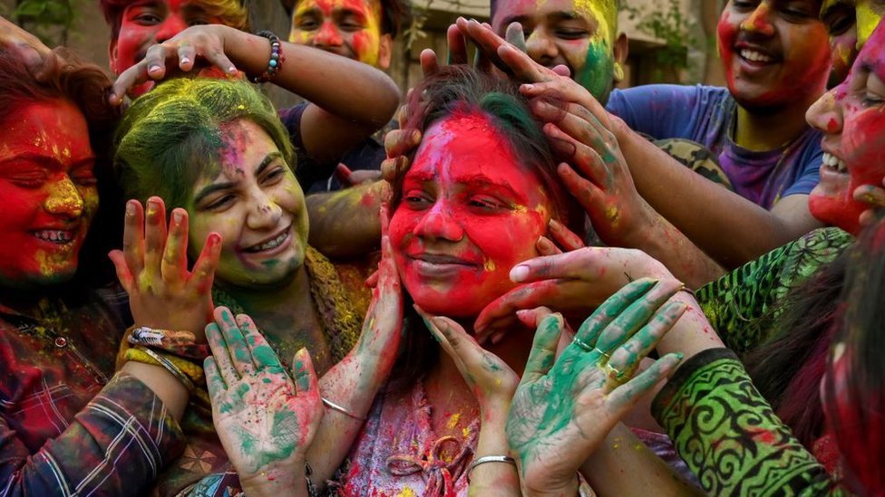 Students daubed in 'Gulal' or coloured powder celebrate Holi, the Hindu spring festival of colours at the Guru Nanak Dev University in Amritsar on March 6, 2023.