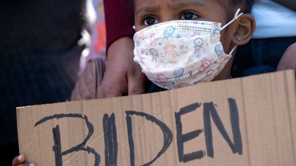 Una niña sostiene un cartel que dice "Biden" en una protesta en el puerto fronterizo de San Ysidro, en Tijuana, el 2 de marzo.