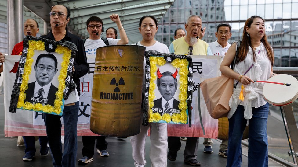 香港反日團體成員舉起「岸田文雄遺照」等抗議道具遊行往日本駐香港總領事館所在辦公樓（24/8/2023）