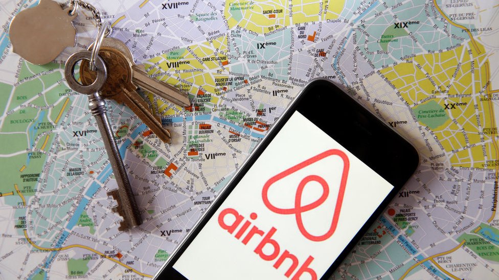 Teléfono celular con Airbnb, mapas y llaves.