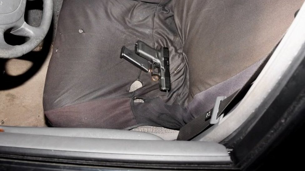A handgun, loaded magazine and a gold ring are seen on the front seat of the vehicle of Black man Jayland Walker, who was shot to death by up to eight officers, in Akron, Ohio, U.S. June 25, 2022