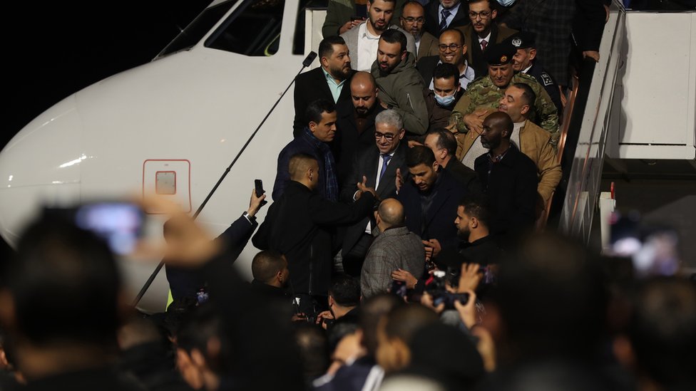 ليبيا: عبد الحميد الدبيبة يتعهد بطرح مشروع قانون انتخاب جديد لحل الأزمة السياسية 1 فتحي باشاغا (وسط) الذي عينه البرلمان الليبي رئيسا للبرلمان، يصل إلى مطار معيتيقة الدولي، في طرابلس، ليبيا، في 10 فبراير/شباط 2022.