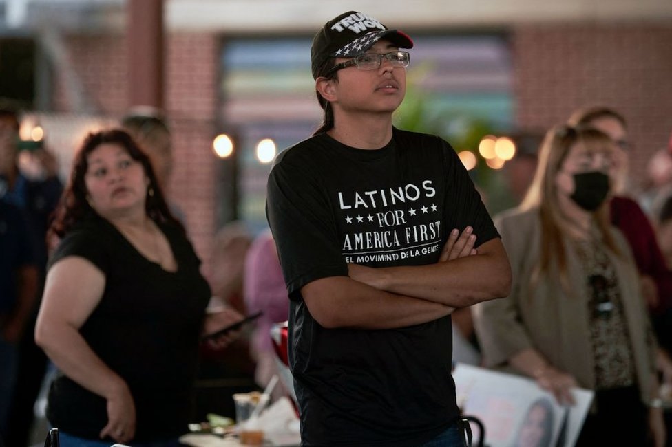 Un joven con una camiseta que dice "Latinos for America" asiste a un acto de campaña de Monica de la Cruz y Mayra Flores, candidatas republicanas a la Cámara de Representantes por el Valle del Río Grande, el 10 de octubre en la Universidad Drafthouse en McAllen, Texas.