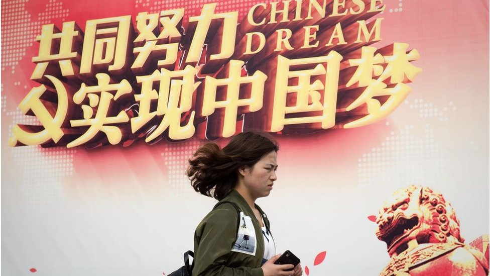 一名婦女走過「實現中國夢」的宣傳廣告牌