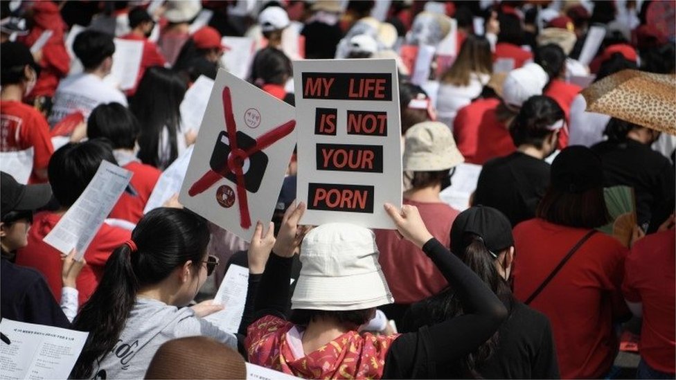 Mujeres con una pancarta en una protesta contra los crímenes sexuales digitales.