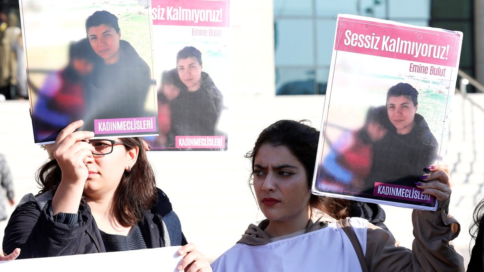Женщины держат плакаты с изображением Эмине Булут, убитой своим мужем, когда они собираются перед судом в Кириккале на первое слушание, 9 октября 2019 г.