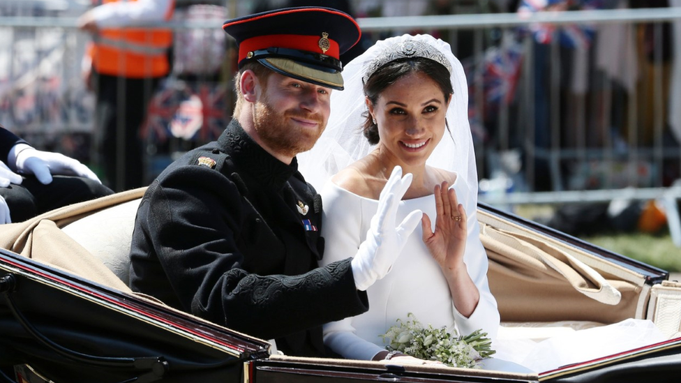 Harry and Meghan wave to crowds from a carriage at their wedding in May 2018