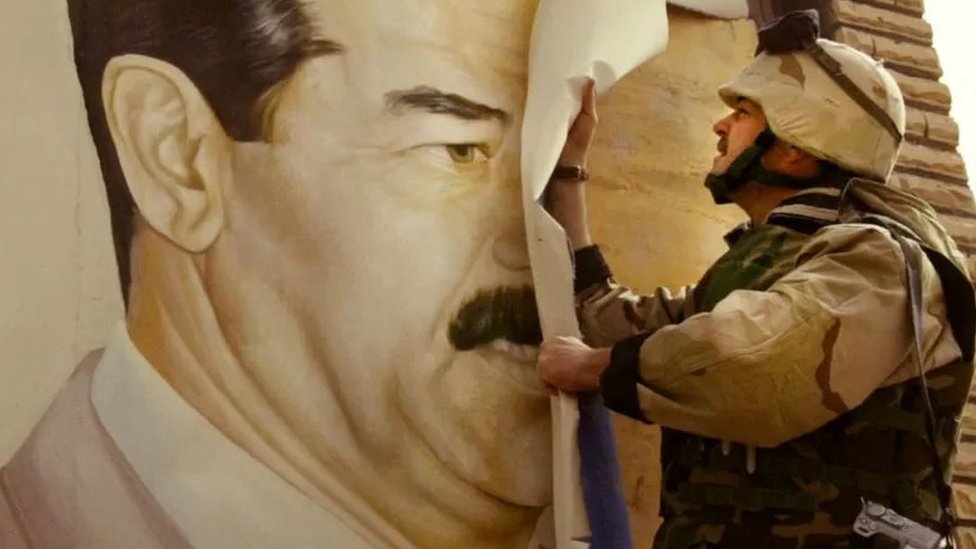 جندي أمريكي ينوع صورة الرئيس العراقي السابق صدام حسين