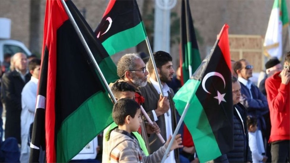 متظاهرون يحملون العلم الليبي