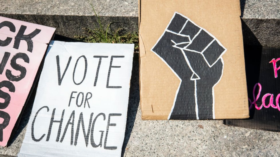 Pancarta que dice "Vote for change"