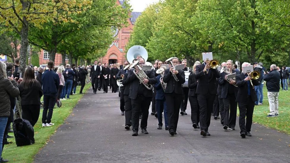 Duvački orkestar, koji je ranije odsvirao pesmu You'll Never Walk Alone, na čelu posmrtne kolone