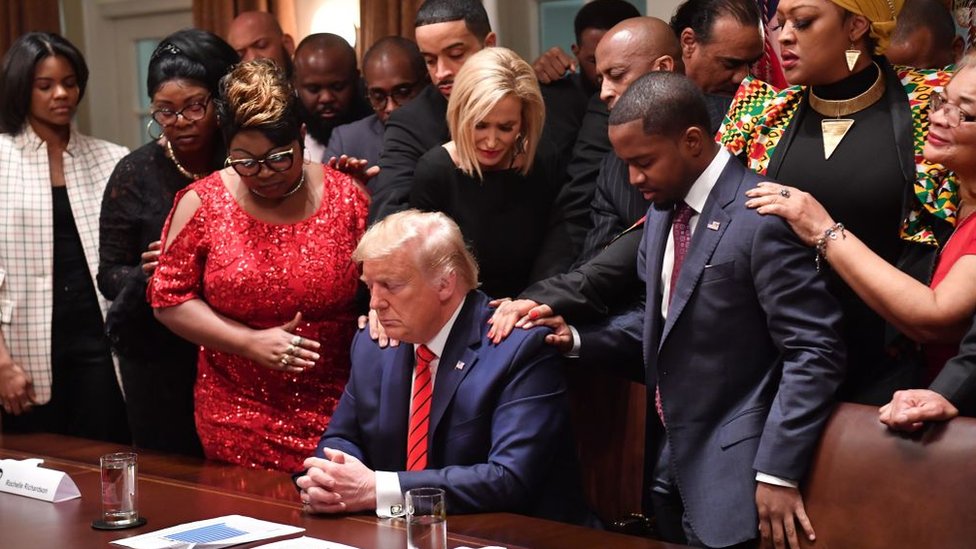 Президент США Дональд Трамп (С) стоит в молитвенном кругу с афроамериканскими лидерами