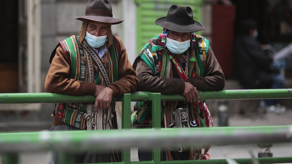 Dois bolivianos andam com máscara de proteção contra a covid-19 na rua