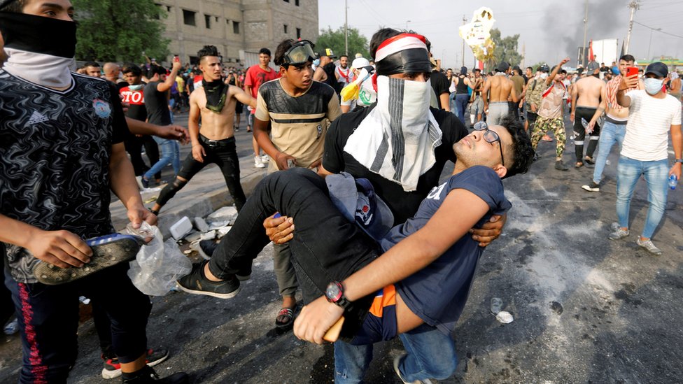 Мужчина уносит раненого демонстранта в Багдаде, Ирак (2 октября 2019 г.)