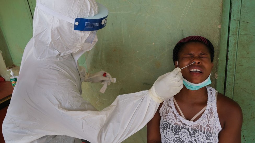 Медицинский работник берет мазок у женщины во время общественной кампании по тестированию на коронавирус COVID-19 в Абудже 15 апреля 2020 г.