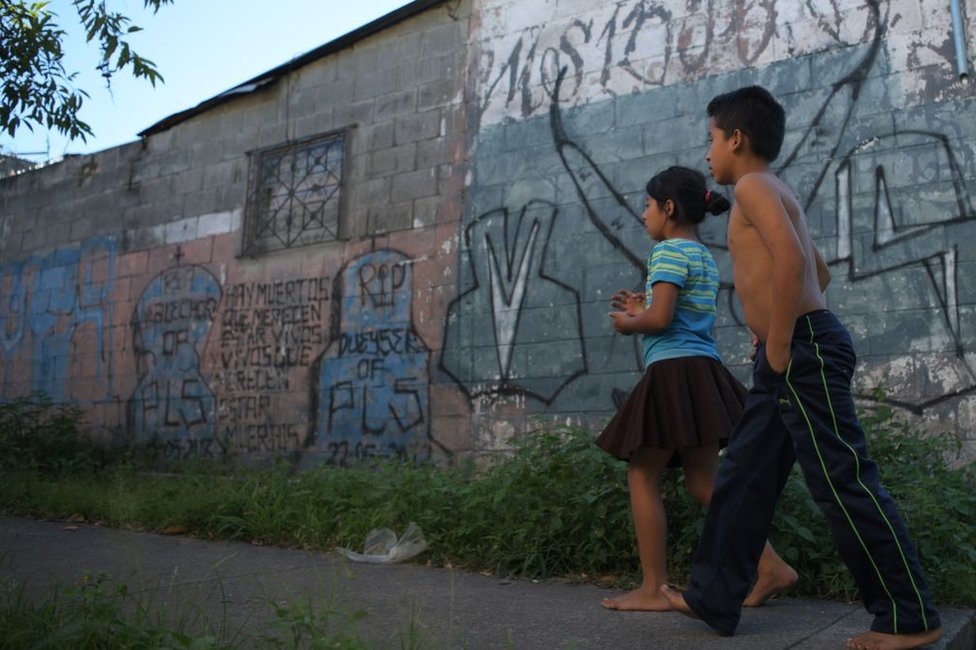 Dos niños caminan ante un grafiti de la Mara Salvatrucha en San Martín, El Salvador, el 15 de noviembre de 2018.