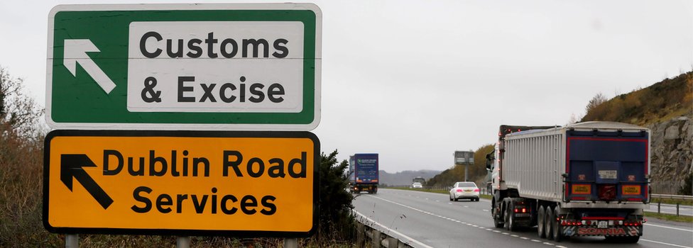 Грузовик проезжает знак на главной дороге за пределами Ньюри, Северная Ирландия