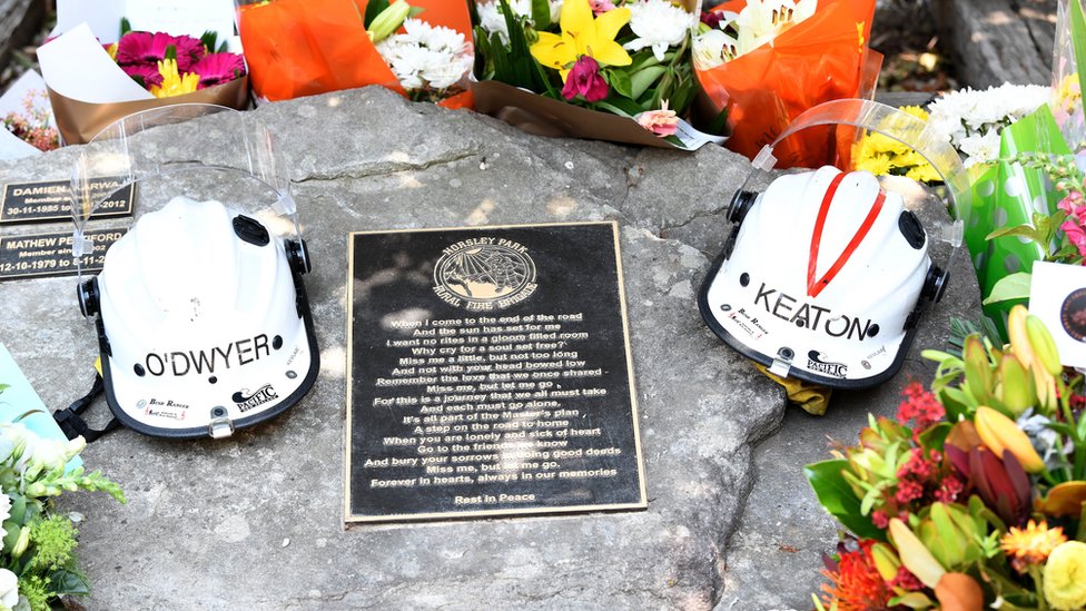 Helmets of Andrew O'Dwyer and Geoffrey Keaton and flowers on their memorial at the Horsley Park fire brigade