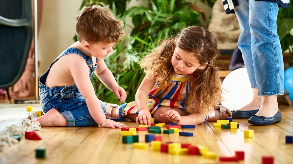 Menino e menina brincando com blocos de madeira