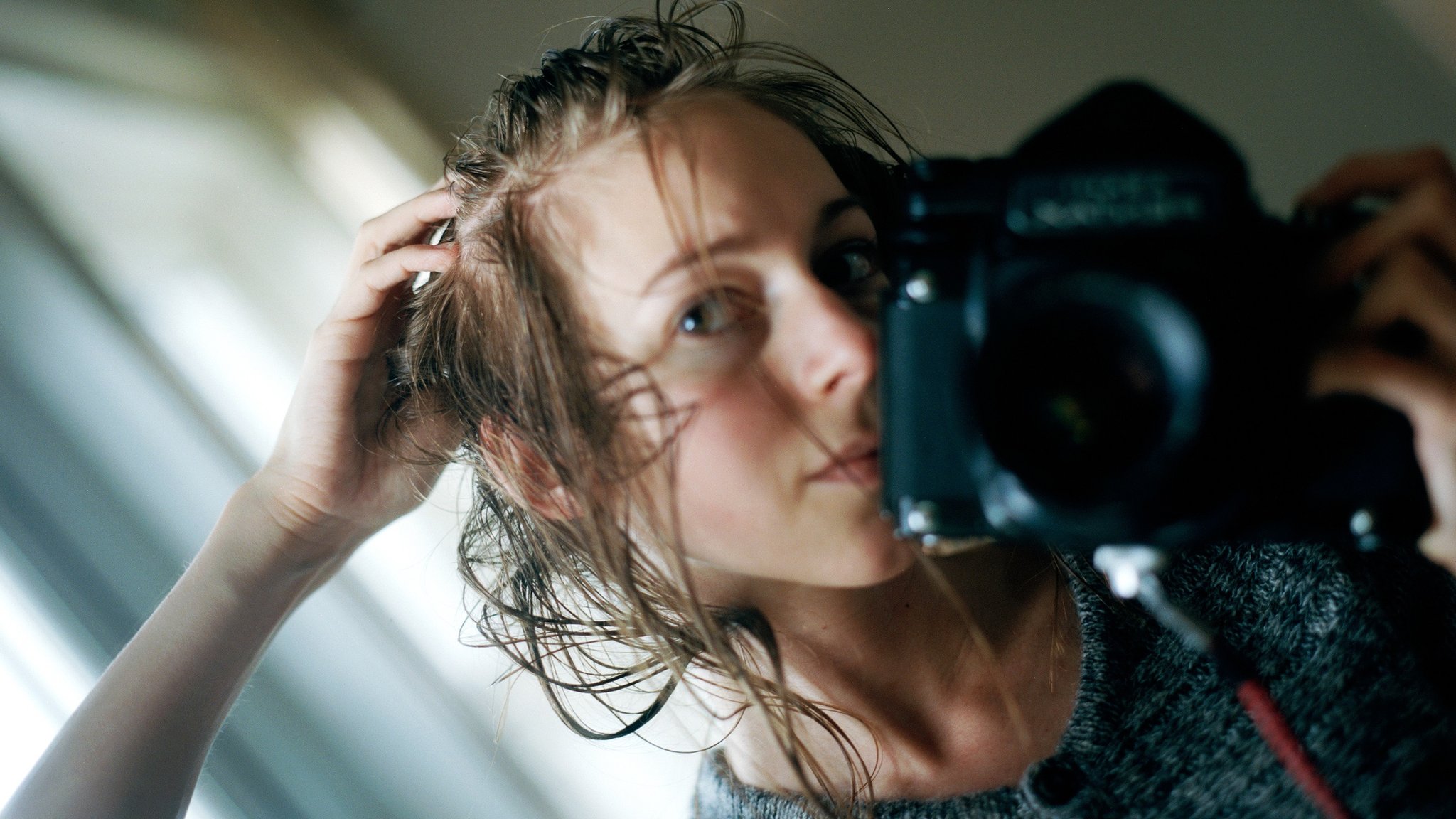 Carly Clarke photographs herself in the mirror at a time when her hair was falling out