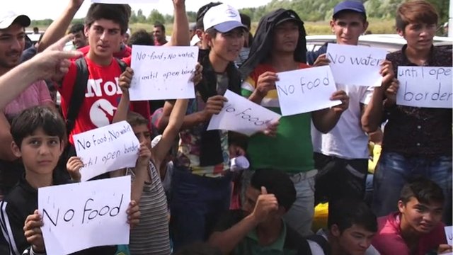 Migrants at the Hungary-Serbia border hold up signs saying "no food"