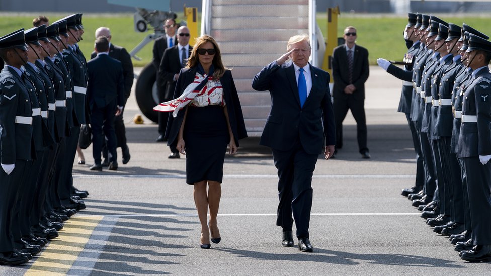 Президент Дональд Трамп (справа) приветствует и первую леди Меланию Трамп (слева), когда они прибывают в лондонский аэропорт Станстед в Эссексе, Великобритания,