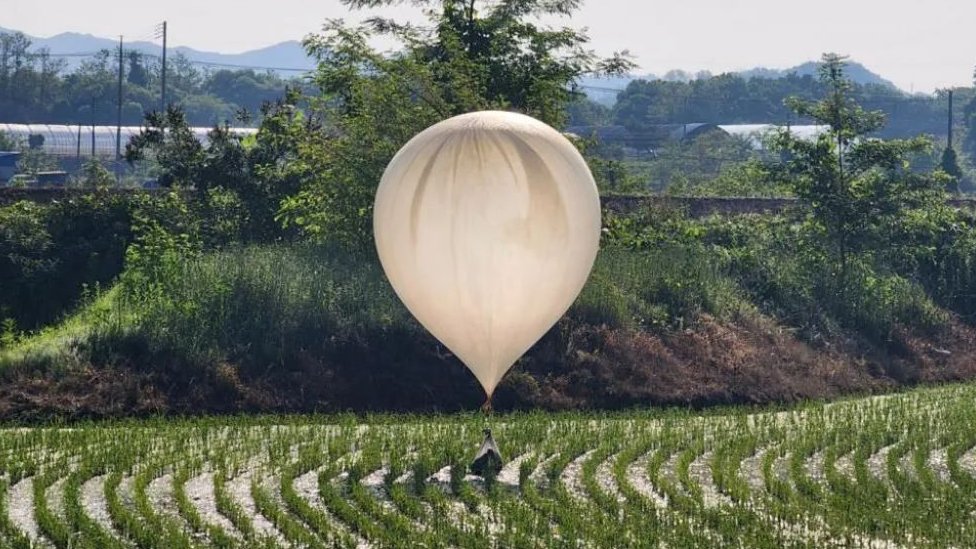 beli balon za koji je prikačena kesa sa smećem