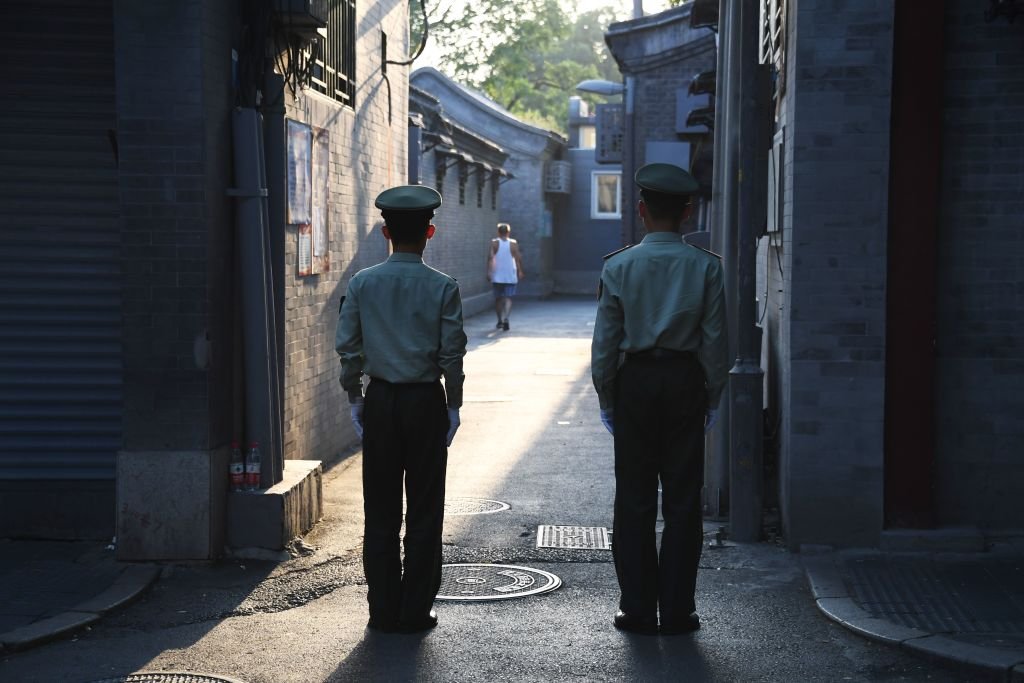 在北京的核心地帶，兩名警衛正在一條胡同內執勤。