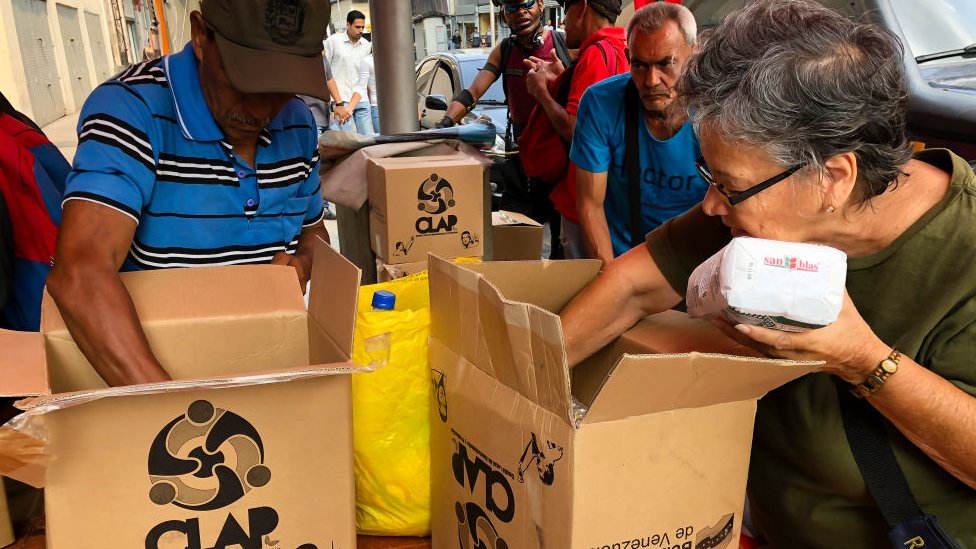 Venezolanos abriendo unas cajas CLAP