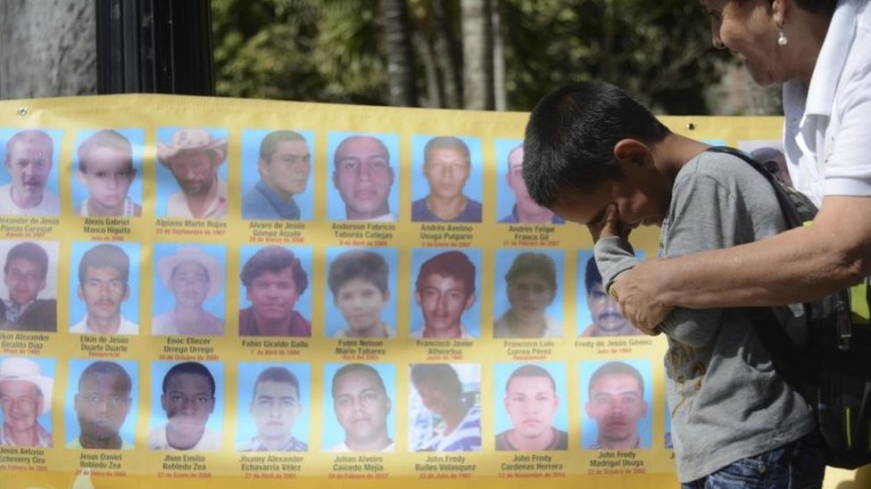 Ребенок плачет перед плакатом с портретами исчезнувших людей 25 сентября 2015 года в Медельине, департамент Антиокия, Колумбия.
