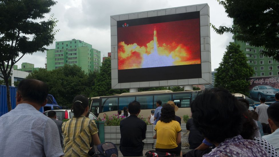 Norcoreanos viendo en una plaza de Pyongyang el lanzamiento de un misil.