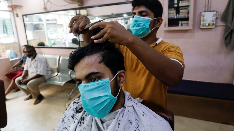 A man wears a protective mask as he has a haircut at a barbershop, after Pakistan lifted lockdown restrictions, as the coronavirus disease (Covid-19) outbreak continues, in Karachi, Pakistan August 10, 2020.