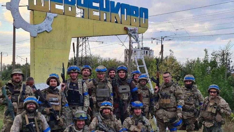 Ukrainian service members pose in what they say is the recently liberated settlement of Vasylenkove in Kharkiv region, Ukraine, on 10 September 2022