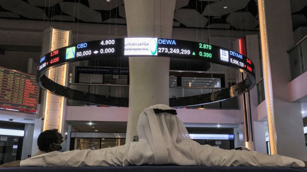 رجل يشاهد تحركات الأسهم على شاشة عرض في سوق دبي المالي للأوراق المالية في الإمارة الخليجية في 12 أبريل/ نيسان 2022