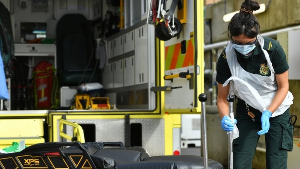 Фельдшер чистит оборудование в зоне дезактивации машины скорой помощи за пределами отделения респираторной оценки