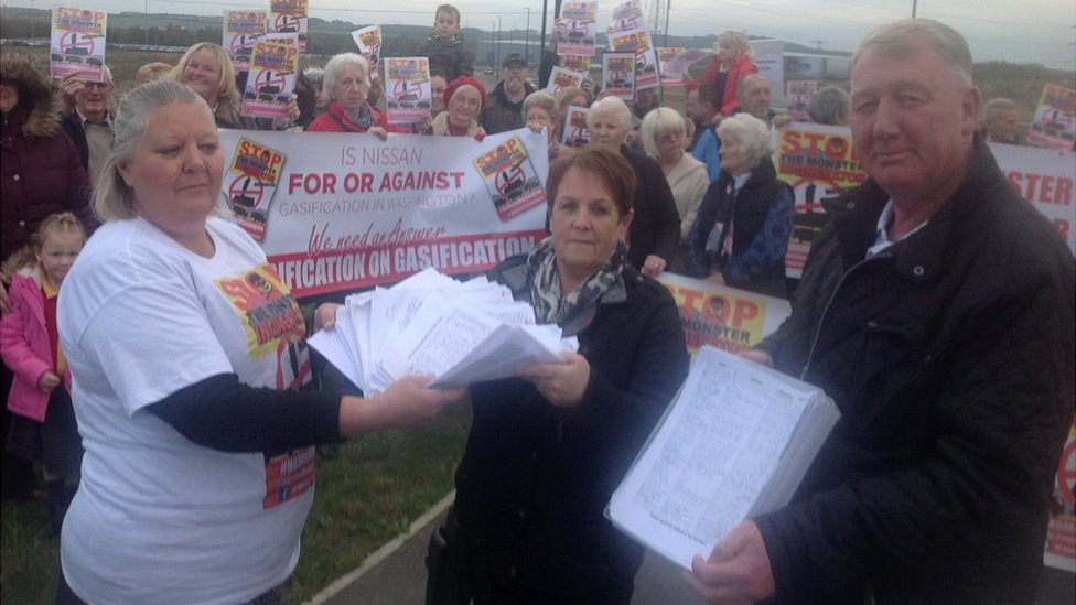 Участники кампании держат петицию против завода по переработке отходов в Вашингтоне