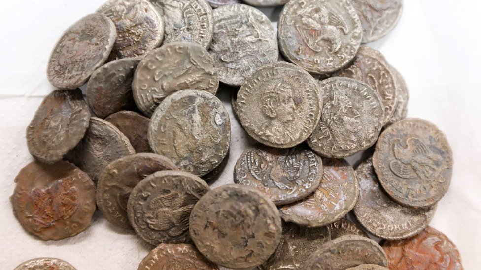 Las monedas romanas antiguas encontradas en un naufragio en el mar Mediterráneo se exhiben en los laboratorios de la Autoridad de Antigüedades de Israel en Jerusalén (22 de diciembre de 2021)