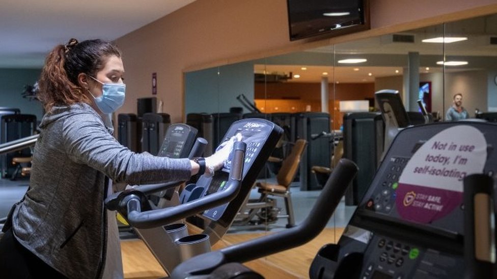 WOman cleaning treadmill in gym