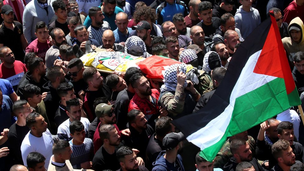 Palestinian mourners carry the body of Palestinian Qusai al-Hamamrah during his funeral in the West Bank town of Husan, near Bethlehem (14 April 2022)