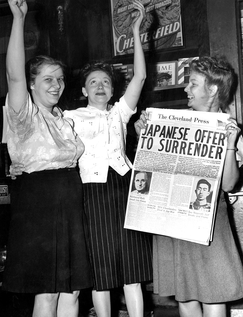 Женщины держат газету и поднимают руки