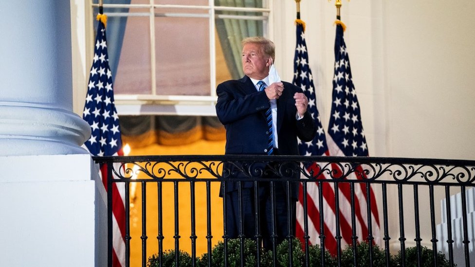 Donald Trump taking off his Covid mask standing outside the White House 