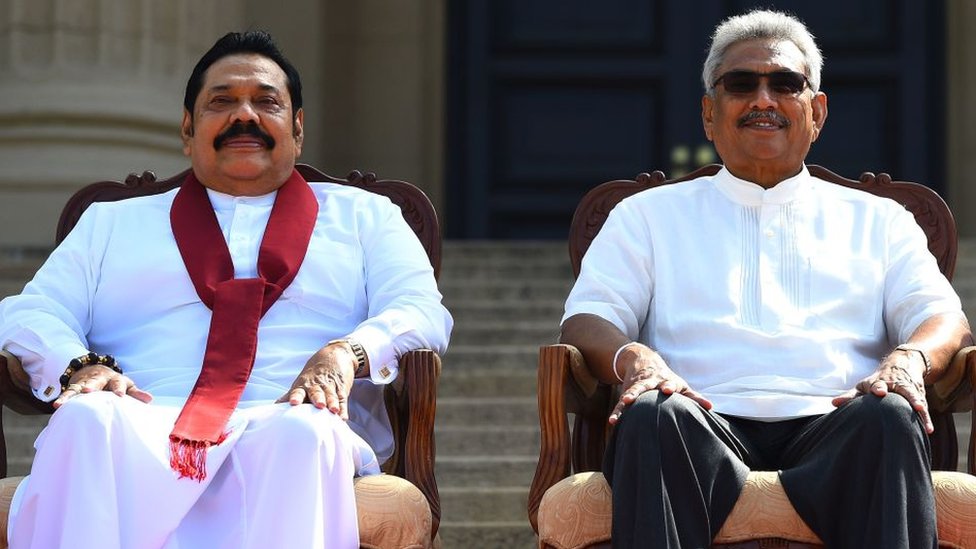 Sri Lanka's new President Gotabaya Rajapaksa (R) and his Prime Minister brother Mahinda Rajapaksa, pose for a group photograph after the ministerial swearing-in ceremony in Colombo on November 22, 2019.
