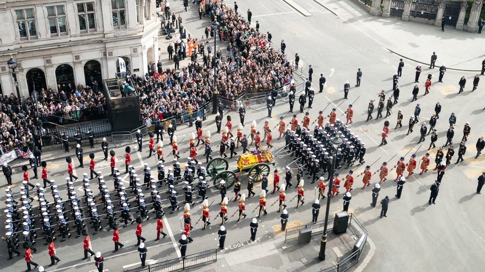 The State Gun Carriage carries the coffin of Queen Elizabeth II, draped in the Royal Standard with the Imperial State Crown and the Sovereign's orb and sceptre, as it leaves Westminster Abbey after the State Funeral of the Queen.