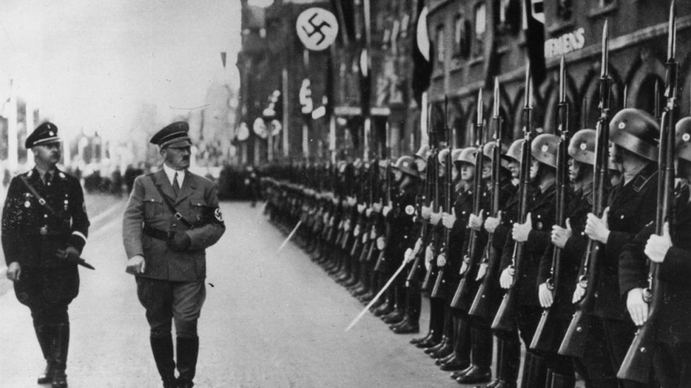 Himmler y Hitler caminan frente a un comando de la SS en 1938.